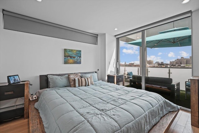 bedroom with wood-type flooring and access to outside