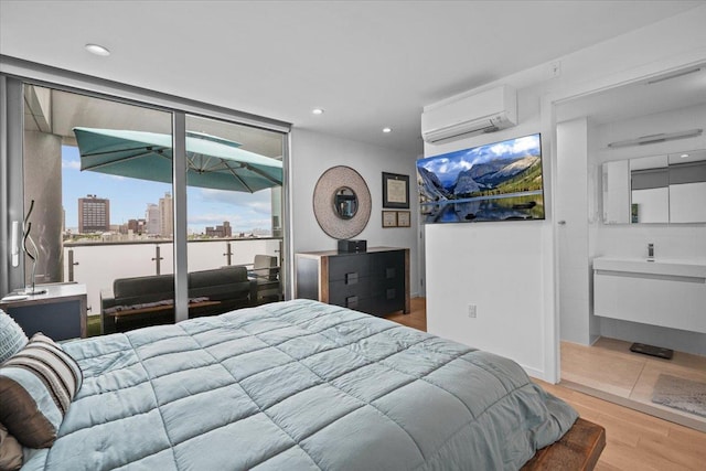 bedroom featuring access to outside, a wall mounted AC, and light wood-type flooring