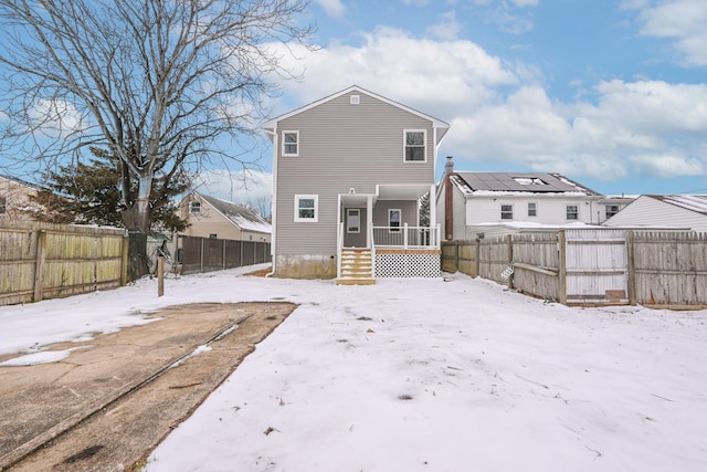 view of snow covered back of property