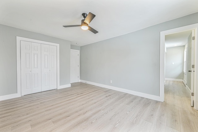 unfurnished bedroom featuring ceiling fan, light wood-type flooring, and a closet