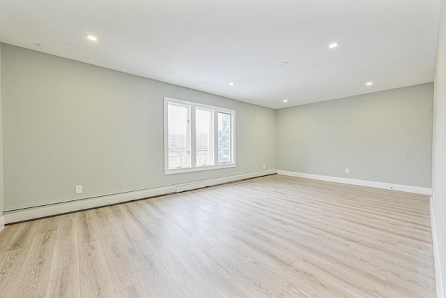 empty room featuring light hardwood / wood-style flooring and a baseboard heating unit