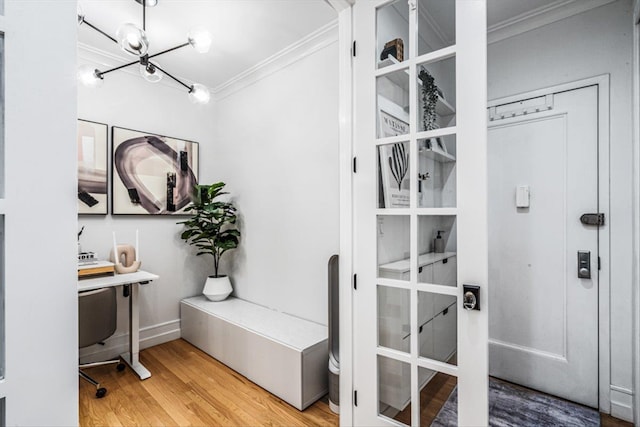 interior space with hardwood / wood-style flooring, ornamental molding, and an inviting chandelier