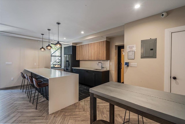 kitchen with pendant lighting, sink, dark parquet flooring, a center island, and electric panel