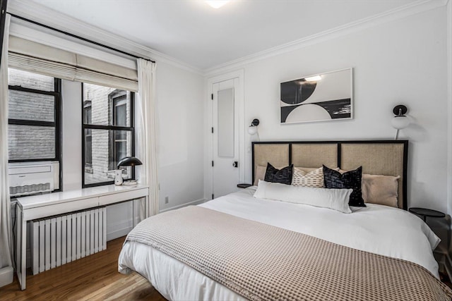 bedroom with crown molding, radiator heating unit, and hardwood / wood-style floors