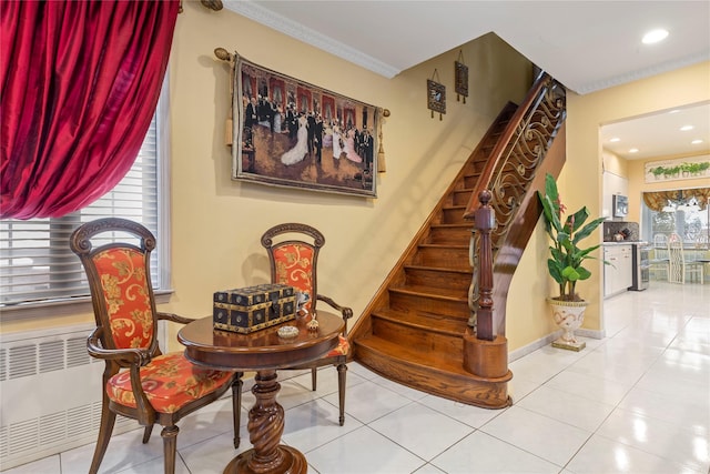 sitting room with crown molding and light tile patterned floors