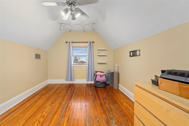 additional living space featuring hardwood / wood-style flooring, vaulted ceiling, and ceiling fan