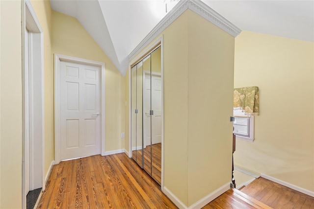 hall with hardwood / wood-style flooring and vaulted ceiling