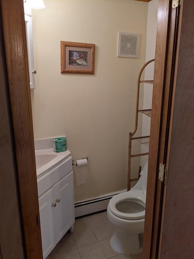 bathroom with toilet, a baseboard heating unit, vanity, and tile patterned flooring