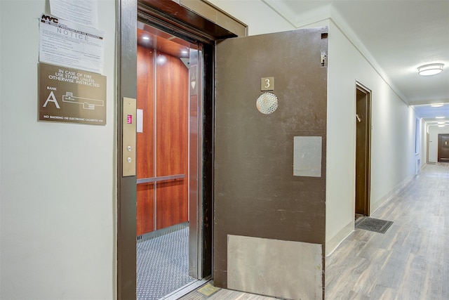 hall with hardwood / wood-style floors