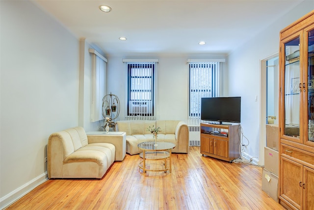 living room featuring radiator heating unit and light hardwood / wood-style flooring