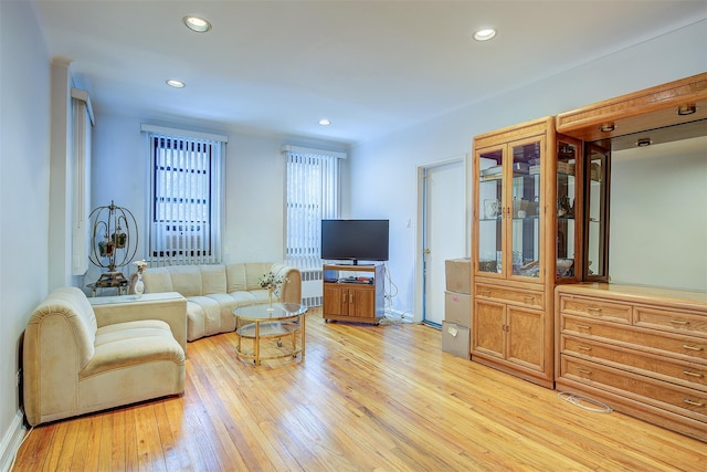 living room featuring radiator heating unit and light wood-type flooring