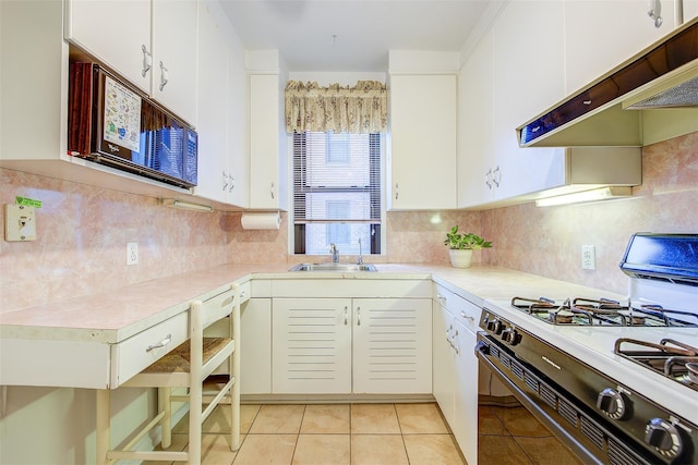 kitchen with range with gas stovetop, white cabinetry, sink, decorative backsplash, and light tile patterned floors