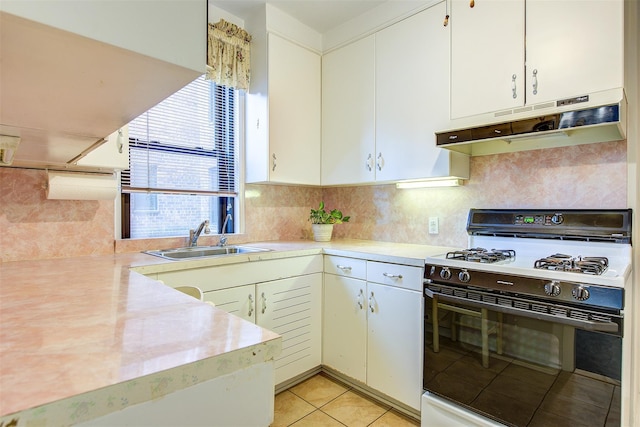 kitchen featuring white cabinetry, sink, white gas range oven, and backsplash