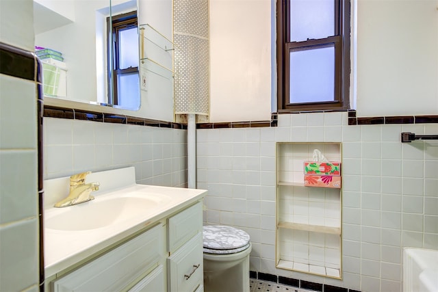 bathroom featuring vanity, toilet, and tile walls