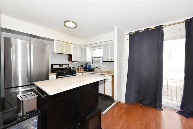 176-17 127th Ave, Jamaica, NY 11434 - kitchen with appliances with stainless steel finishes, wood finished floors, light stone countertops, white cabinetry, and a sink