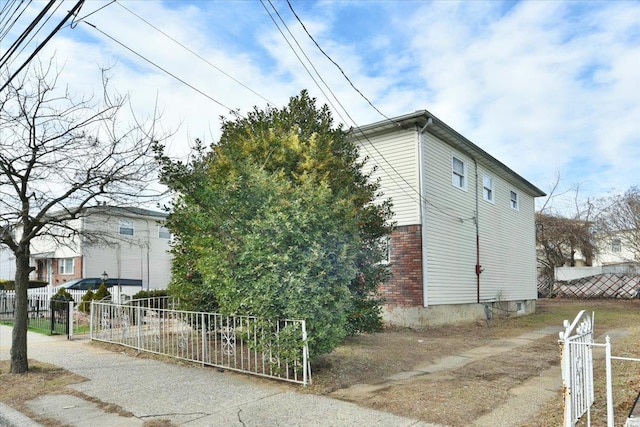 view of home's exterior featuring fence and brick siding