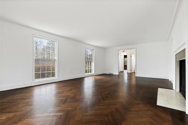 unfurnished living room featuring ornamental molding and baseboards