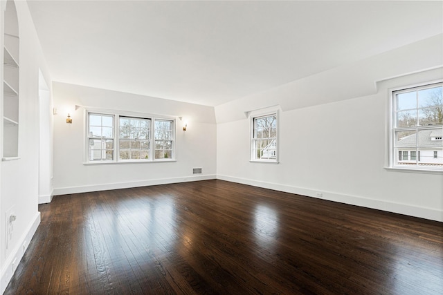 unfurnished room with dark wood-style floors and baseboards