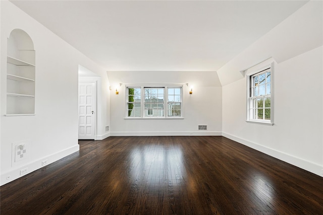 unfurnished room featuring built in features, visible vents, dark wood finished floors, and baseboards