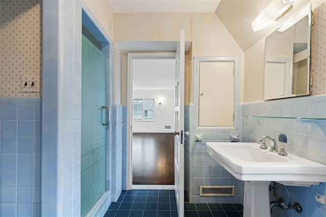 bathroom featuring a wainscoted wall, tile walls, a stall shower, tile patterned flooring, and wallpapered walls