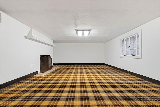 interior space with carpet floors, a fireplace, and baseboards