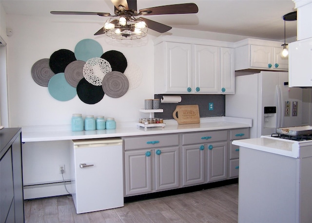 kitchen with white cabinetry, decorative light fixtures, light wood-type flooring, baseboard heating, and white fridge with ice dispenser