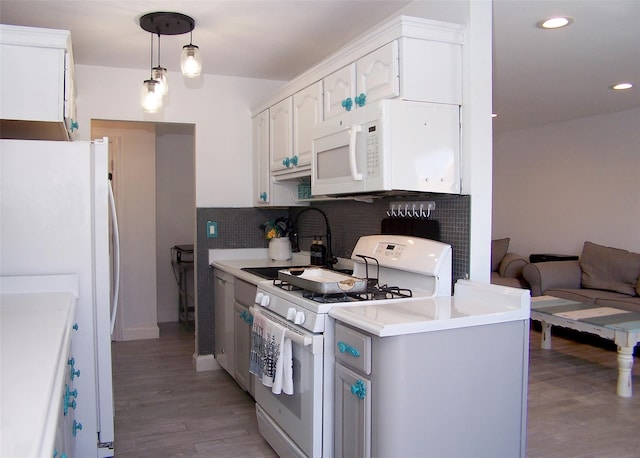 kitchen with sink, decorative light fixtures, white cabinets, white appliances, and backsplash