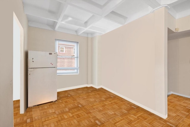 empty room with coffered ceiling, beamed ceiling, and baseboards