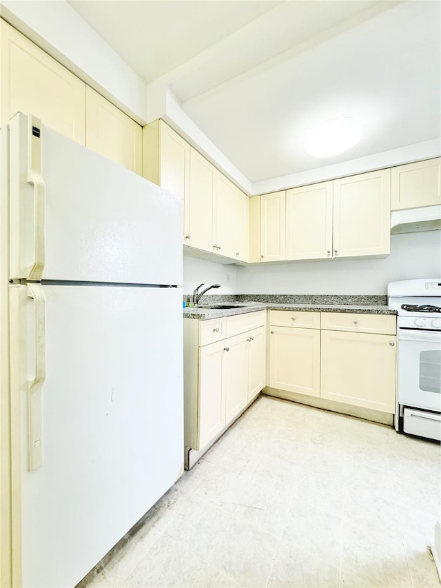 kitchen featuring sink, white appliances, and cream cabinetry