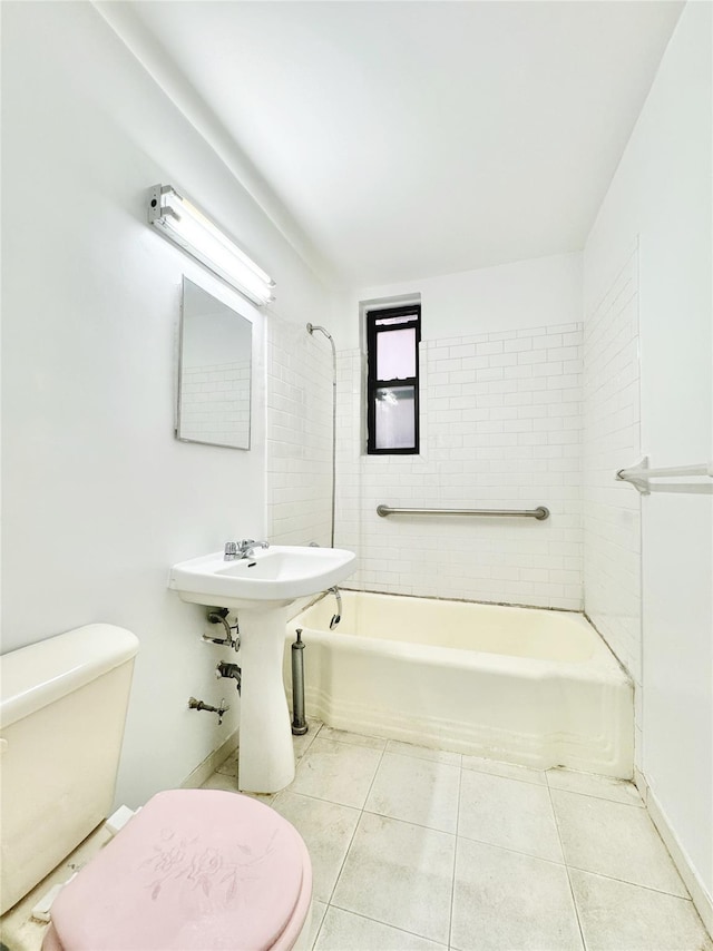 bathroom with tiled shower / bath, tile patterned floors, and toilet