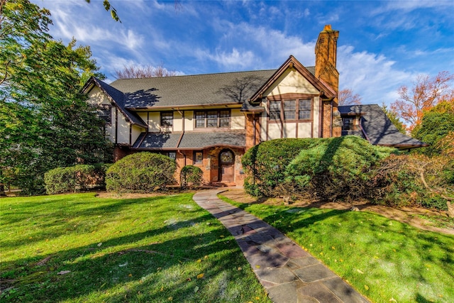 english style home with a front lawn