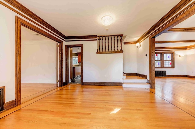 empty room featuring crown molding, radiator, and light hardwood / wood-style floors