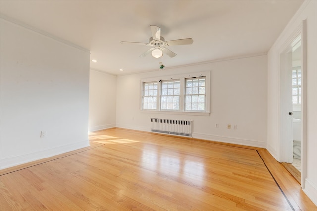 unfurnished room featuring crown molding, radiator heating unit, ceiling fan, and light wood-type flooring