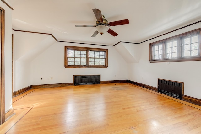 additional living space featuring lofted ceiling, radiator heating unit, and wood-type flooring