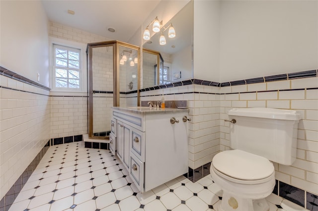 bathroom featuring toilet, a shower with shower door, and tile walls