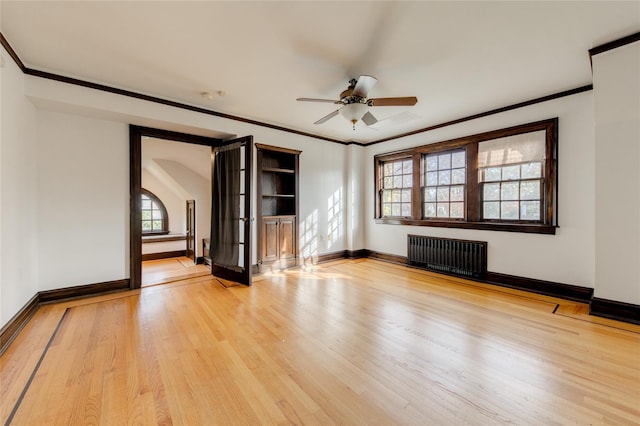 unfurnished living room with ornamental molding, radiator heating unit, ceiling fan, and light wood-type flooring