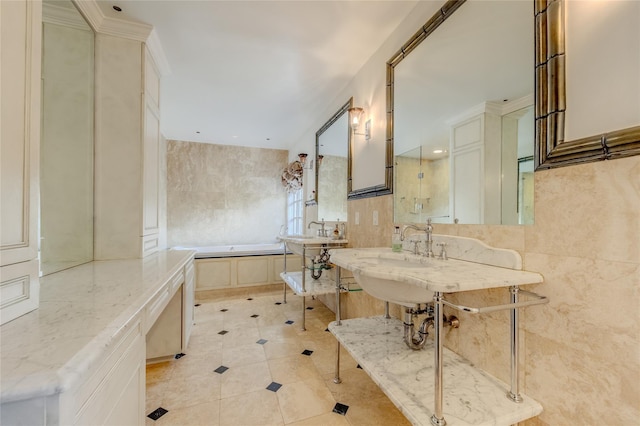 bathroom with a bathing tub, sink, and tile walls