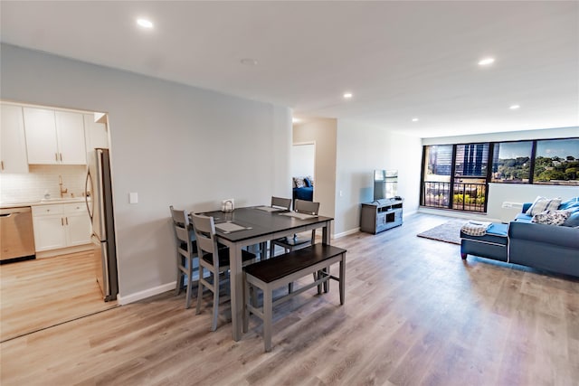 dining area featuring sink and light wood-type flooring