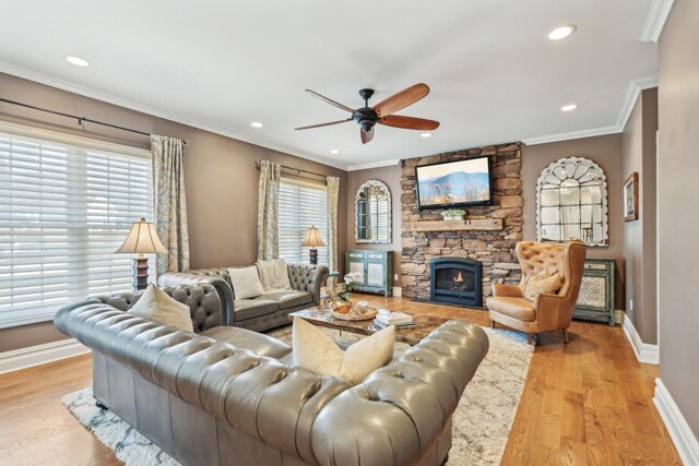 living room featuring ornamental molding, a fireplace, baseboards, and wood finished floors