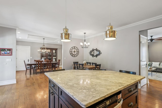 kitchen with ornamental molding, wood-type flooring, and hanging light fixtures