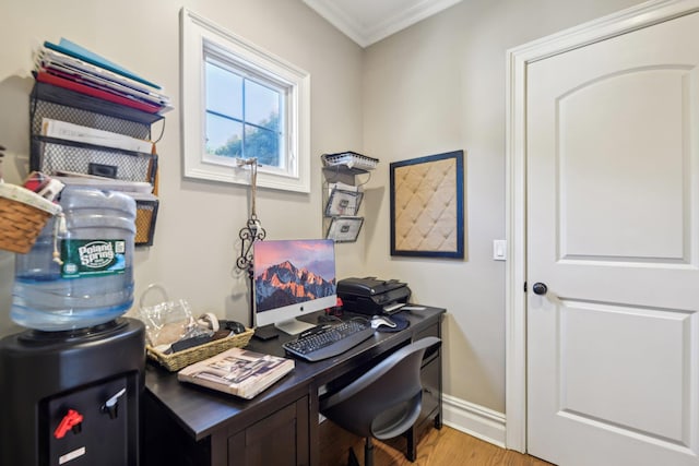 office space featuring baseboards, light wood finished floors, and crown molding