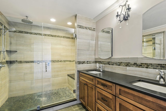 full bathroom featuring crown molding, a sink, a shower stall, and double vanity