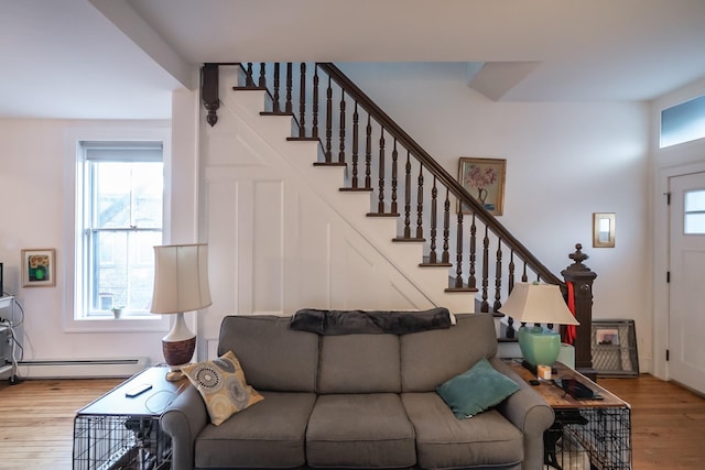 living room featuring plenty of natural light, a baseboard heating unit, and light hardwood / wood-style flooring