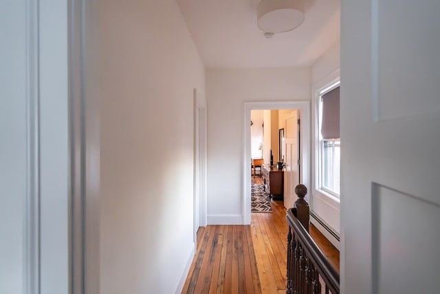 hall with a baseboard radiator and light hardwood / wood-style flooring