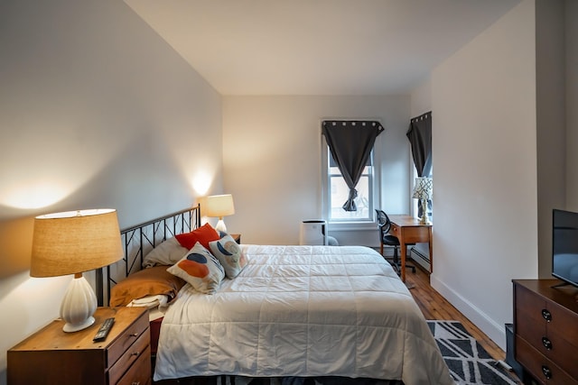 bedroom with hardwood / wood-style flooring and a baseboard radiator