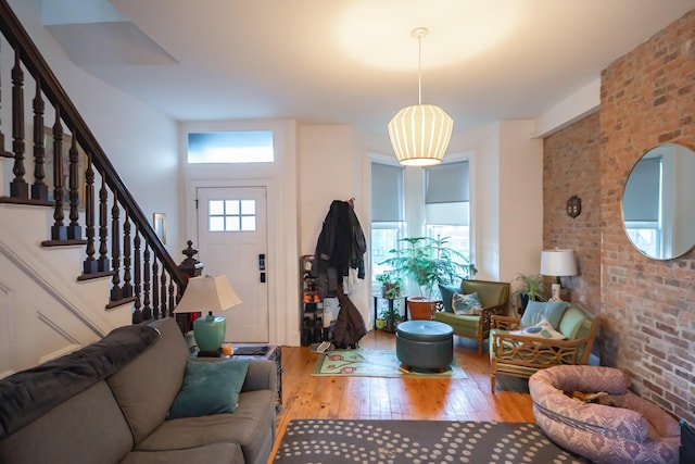 living room with hardwood / wood-style floors and brick wall