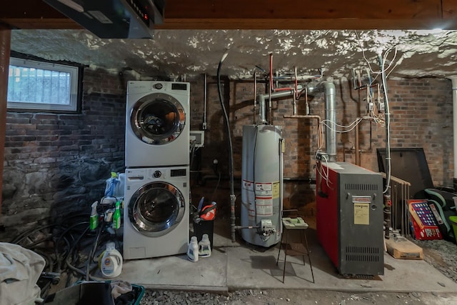 washroom with water heater, brick wall, and stacked washer and clothes dryer