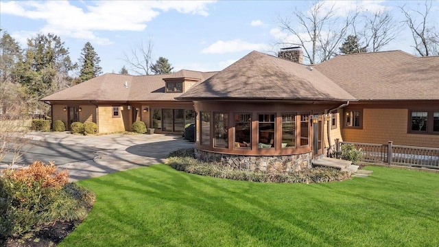 rear view of house featuring a yard