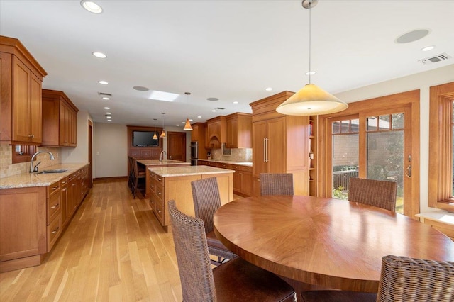 dining area with sink and light hardwood / wood-style flooring