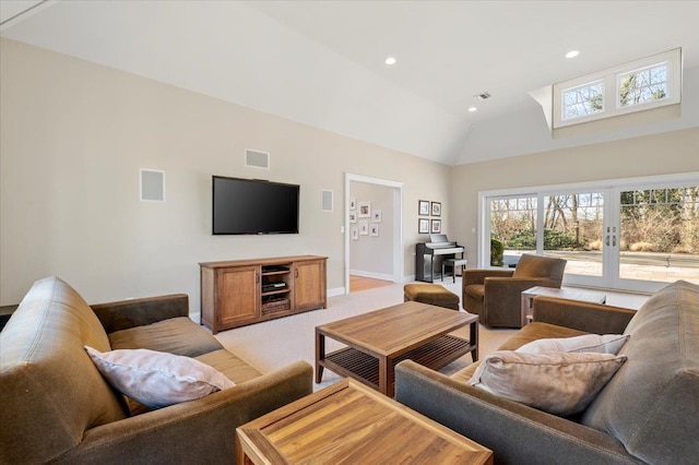 carpeted living room with high vaulted ceiling and french doors